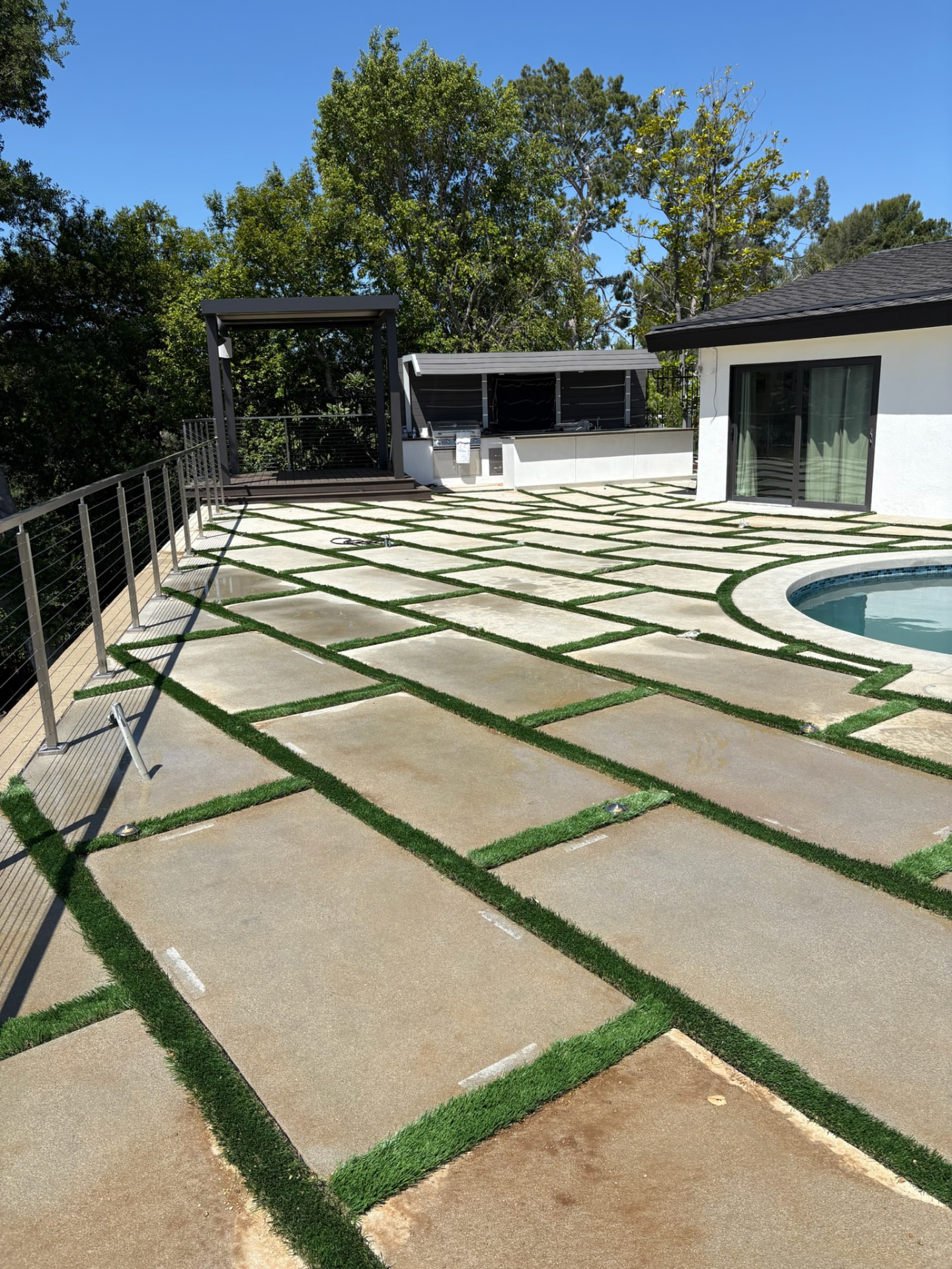 Poolside patio with concrete pavers and turf joints built by Castillo Groundworks